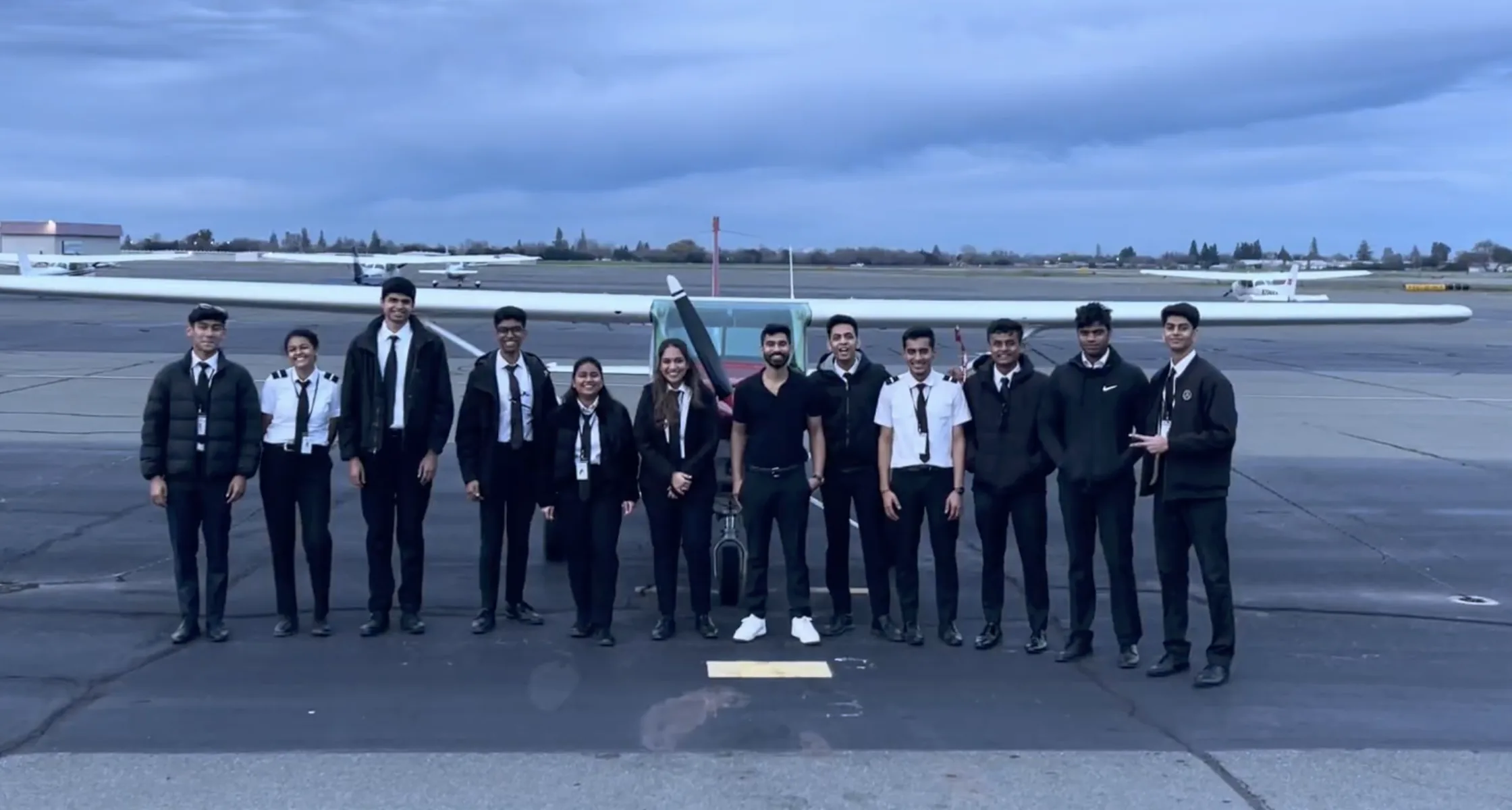 AIAA cadet pilots standing with training aircraft on the apron