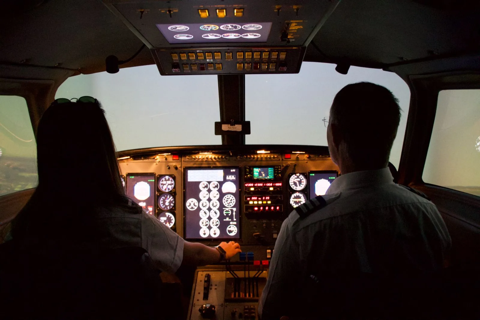 Cadet and instructor in a flight simulator cockpit