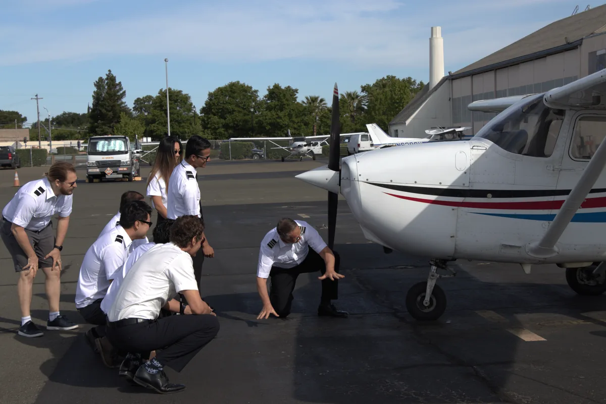 Cadet pilot doing a pre-flight walkaround with an instructor
