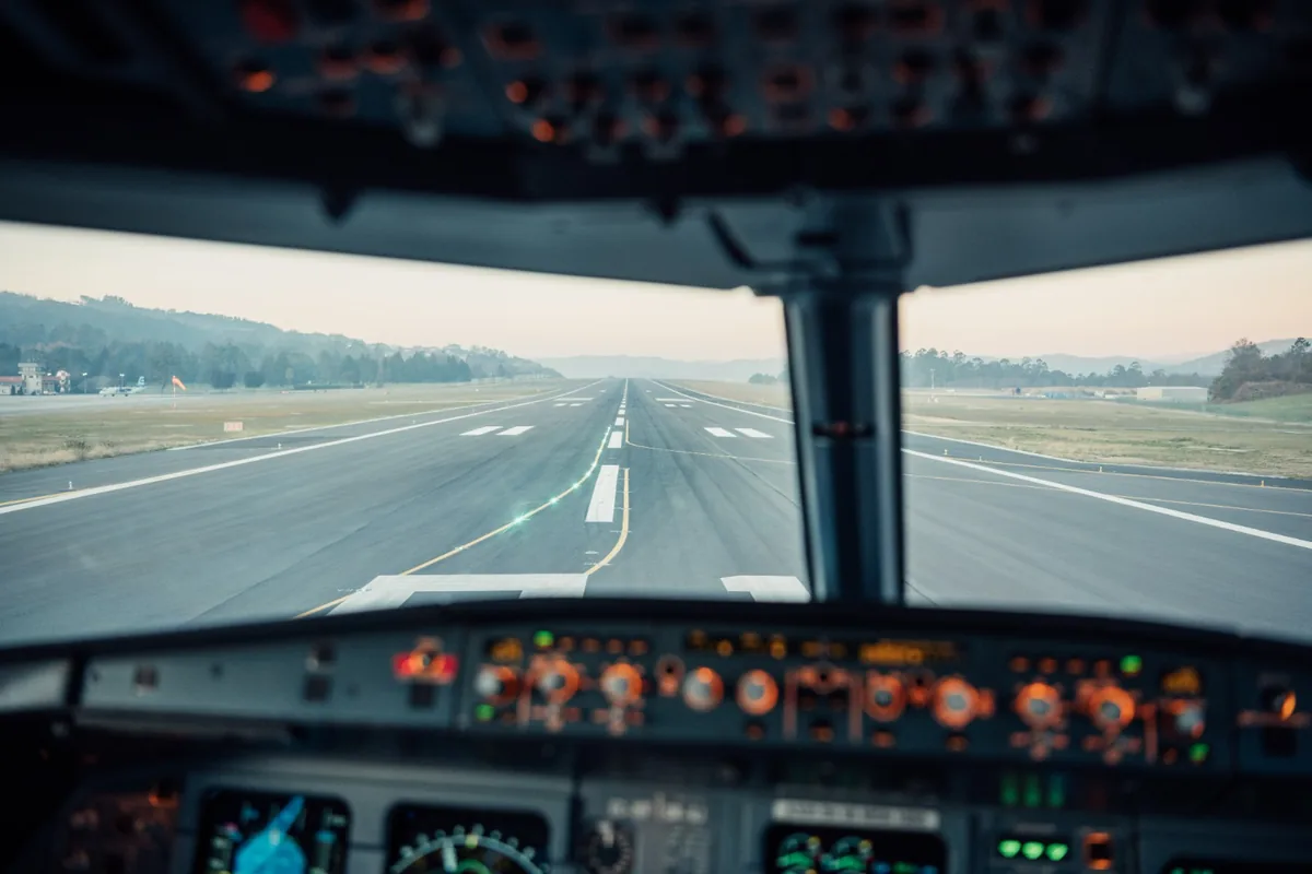 Looking down the runway from an airliner cockpit at dusk